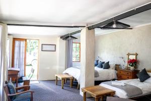 a bedroom with two beds and a table at Douglas Drift Cottages in Underberg