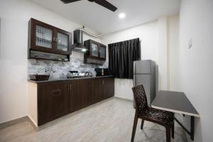a kitchen with a table and a refrigerator at Rayzen Stays & Backpackers Hostel in Chennai