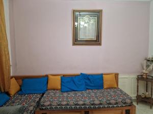 a couch with blue and orange pillows in a room at Dar Mima in Tunis +8 photos