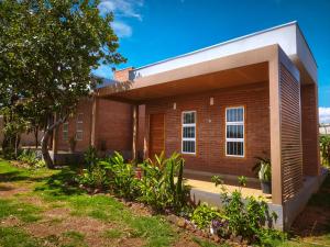 a brick house with a white roof at ChapadaFlats in Chapada dos Guimarães