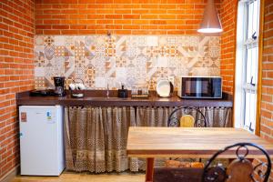 a kitchen with a counter with a microwave and a table at ChapadaFlats in Chapada dos Guimarães