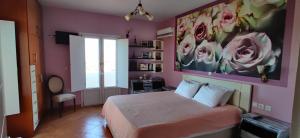 a bedroom with a bed with a painting on the wall at Villa Santa Mavra in Glinado Naxos +83 photos