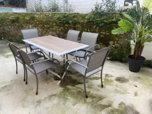 a table and chairs with a table and a plant at Appartement Le Pellerin 2ch et 2sdb in Le Pellerin