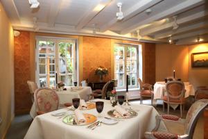 a restaurant with white tables and chairs and windows at Hotel Krone in Hayna