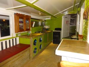 a green kitchen with a sink and a counter at Cocopele Inn in San Ignacio
