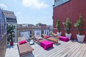 una fila de bancos sentados en una terraza en la azotea en Apartment Barcelona Rentals - Pool Terrace in City Center en Barcelona