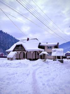 a house with snow on the roof of it at Садиба у "Степана" in Synevyrsʼka Polyana