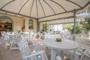 an empty restaurant with white tables and white chairs at Hotel Dover Rooms & Coffee Adults Friendly in Cervia