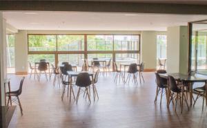 an empty room with tables and chairs and windows at Cobertura vista mar in Natal