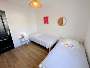 a small room with two beds and a mirror at Villa Le Nid du Pont d'Arc in Vallon-Pont-dʼArc +20 photos