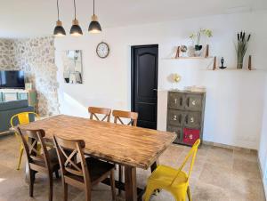 a dining room with a wooden table and chairs at Villa Le Nid du Pont d'Arc in Vallon-Pont-dʼArc