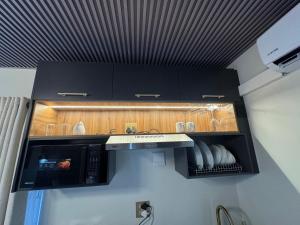a kitchen with black cabinets and a microwave at G - Boutique in Durban