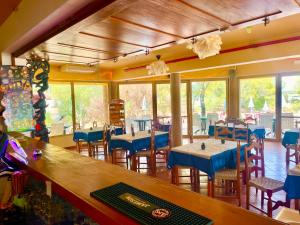ein Restaurant mit blauen Tischen, Stühlen und Fenstern in der Unterkunft Markádia in Odivelas