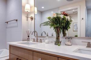 a bathroom with two sinks and a vase of flowers at Abode at Sky Silver Edge in Park City +36 photos
