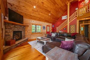 a living room with a leather couch and a fireplace at The Hygge Chalet by Railey Vacations in McHenry