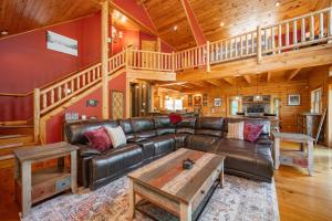 a living room with a leather couch and a wooden ceiling at The Hygge Chalet by Railey Vacations in McHenry