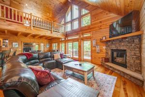 a living room with a leather couch and a fireplace at The Hygge Chalet by Railey Vacations in McHenry