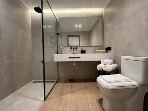 a bathroom with a sink and a toilet and a mirror at Hotel Boutique Ubuntu in Buenos Aires