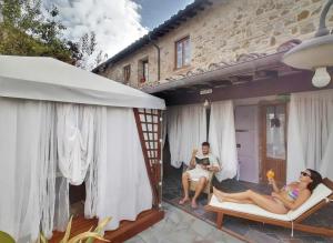 two people sitting on the porch of a house at La Suite Toscana in Certaldo +70 photos