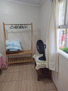 a room with a bed and a chair and a window at Apartamento sossegado e bairro tranquilo in Torres