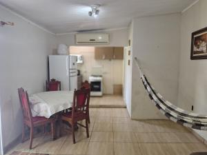 a kitchen and dining room with a table and chairs at Apartamento sossegado e bairro tranquilo in Torres