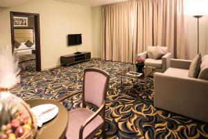 a hotel room with a living area with a couch and chair at Emirates Plaza Hotel in Abu Dhabi