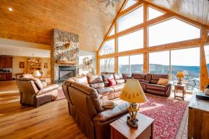 a living room with leather furniture and a large window at Bear Cliff Lodge by Railey Vacations in Friendsville
