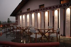 a group of tables and chairs on a building with lights at Mud & Meadows- A Satvik Farmstay, Jamshedpur in Jamshedpur