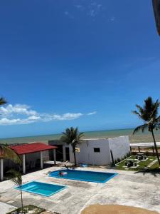 a resort with two swimming pools next to the beach at Pousada Sol Nascente in Mucuri +21 photos