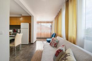 a living room with a couch and a kitchen at Casa Vereda do Calhau - With barbecue in Campanário