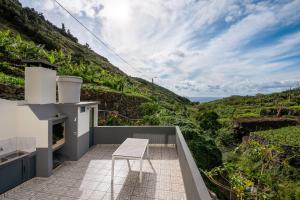 a white chair sitting on a balcony with a view at Casa Vereda do Calhau - With barbecue in Campanário