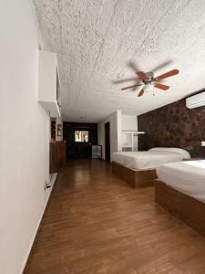 ein Schlafzimmer mit zwei Betten und einem Deckenventilator in der Unterkunft Mi ranchito samao in Chichicasta + 66 Fotos