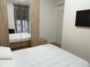 a bedroom with a white bed and a mirror at Zuretti House in Milan