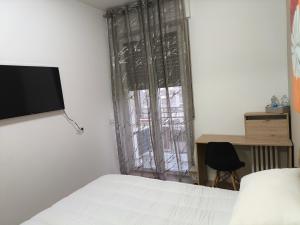 a bedroom with a bed and a desk and a window at Zuretti House in Milan