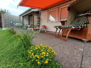 a backyard with a table and chairs and flowers at Ferien-Bungalow Wiesenweg in Timmendorfer Strand