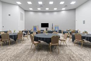 a conference room with tables and chairs and a screen at Plantation Inn in Houma +58 photos