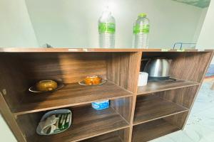 a wooden book shelf with bottles and dishes on it at I Daa Pra-ea Guesthouse in Phra Ae beach