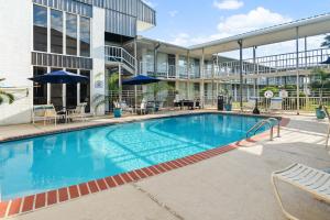 a large swimming pool in front of a building at Plantation Inn in Houma