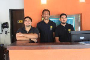 three men standing in front of a desk at Pousada Vila do Sol in Búzios +287 photos