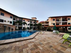 a swimming pool in front of a building at Studio Completo a 2min da Praia e Beach Park in Aquiraz