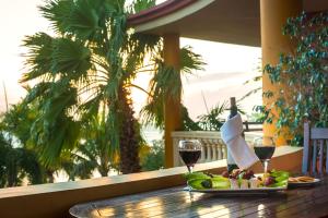 een tafel met een bord eten en twee glazen wijn bij Aruba Surfside Marina in Oranjestad