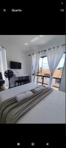 a bedroom with a bed with a view of the ocean at Suíte 25 vista para o mar in Pontal do Paraná