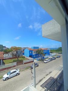 a view of a street with cars parked on the road at Suíte 25 vista para o mar in Pontal do Paraná