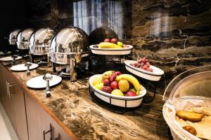 a buffet with bowls of fruit on a counter at Emirates Plaza Hotel in Abu Dhabi