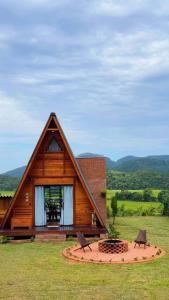 a house with a fire pit in front of it at Chalé Nascer do Sol 2 in Massaranduba