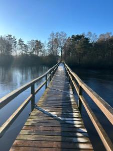 a wooden bridge over a body of water at Linnis Strandhaus in Garrel