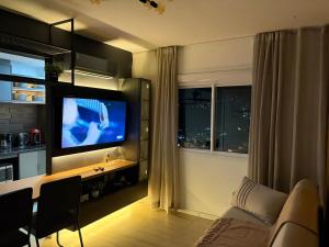 a living room with a flat screen tv and a couch at Loft completo, garagem, piscina aquecida, jacuzzi in Porto Alegre