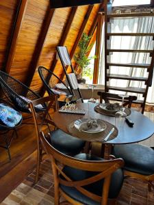 a dining room with a table with a laptop on it at Chalé Nascer do Sol 2 in Massaranduba