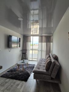 a living room with a couch and a large window at Mavile ViSa in La Tebaida