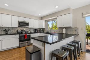 a kitchen with white cabinets and a counter with stools at High Country Rretreat in Flagstaff